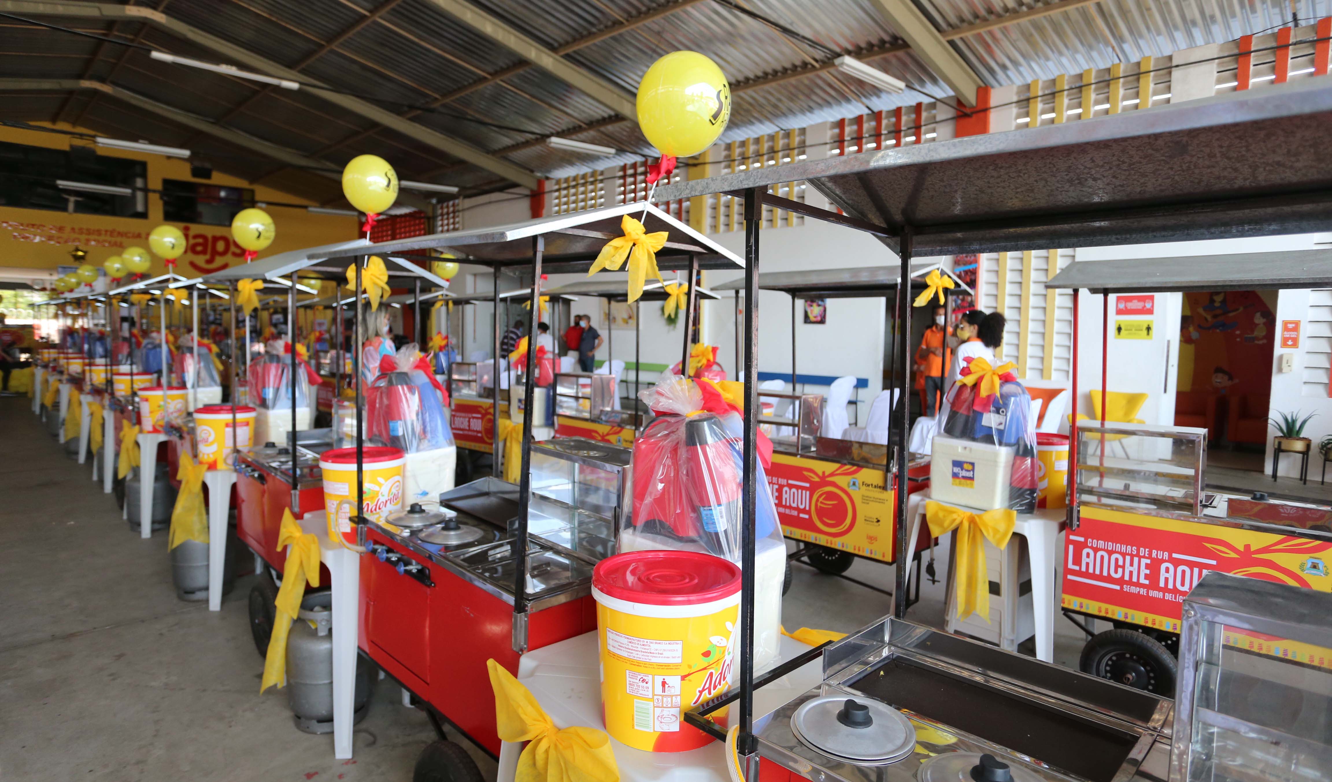 carrinhos junto com kits, com isopor, garrafas térmicas, mesa, botijão de gás